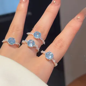 Gedetailleerde macro-opname van elegante lichtblauwe zirkoon bloemringen met 18k goud