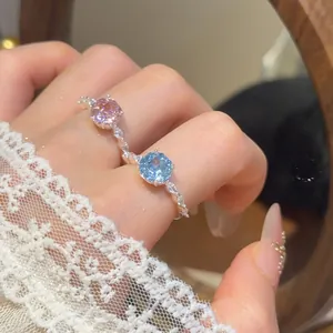 Gedetailleerde close-up van elegante verstelbare ringen met roze en blauwe zirkoonstenen
