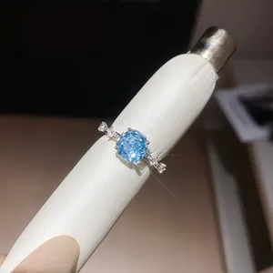 Gedetailleerde macro-opname van een sprankelende blauwe zirkoonring met bloemsnede