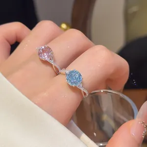 Detail van 18k vergulde bloemringen met sprankelende roze en blauwe gefacetteerde stenen
