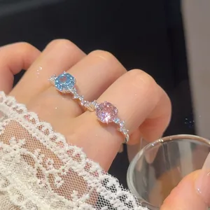 Detailopname van een 18k vergulde verstelbare ring met blauwe en roze zirkonia stenen