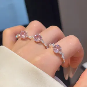 Detail van drie elegante open ringen met gefacetteerde roze zirkoonstenen op hand