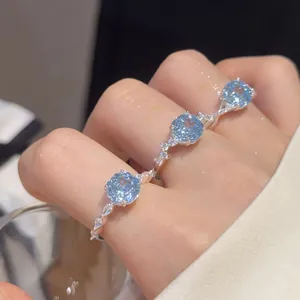 Detailopname van een 18k vergulde open ring met drie lichtblauwe zirkonia facetgeslepen