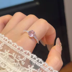 Elegante detailopname van een roze zirkoon open ring met 18k vergulding om de vinger