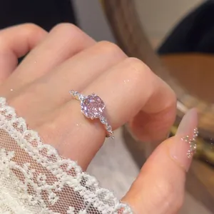 Detailopname van een elegante bloemvormige ring met een roze gefacetteerde edelsteen.