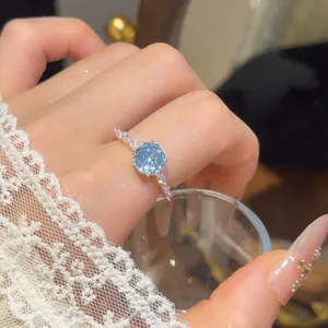 Detailopname van een elegante 18k vergulde open ring met lichtblauwe zirkonia