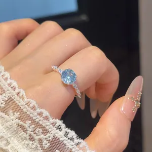 Close-up van een elegante 18k vergulde ring met een sprankelende blauwe zirkonia.