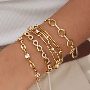 Primer plano de pulseras multicapa de acero de titanio dorado con detalles de circón.