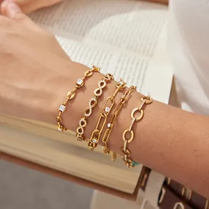 Vista detallada de cinco pulseras de acero de titanio dorado con circonitas brillantes.