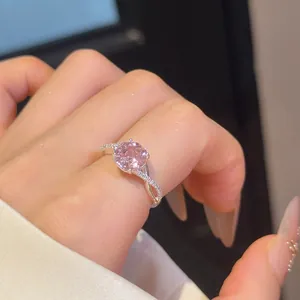 Detailopname van een 18k vergulde open ring met een sprankelende roze zirkoon gem.