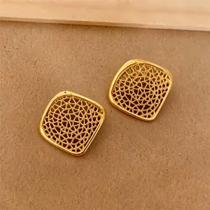 Makroansicht des goldenen Maschenmusters dieser quadratischen geometrischen Ohrstecker.