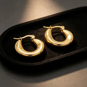 Vista macro profesional de pendientes de aro en forma de U de oro pulido en terciopelo