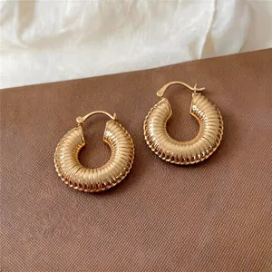 Detailansicht eleganter goldfarbener strukturierter Creolen mit klassischem Vintage-Rillen-Design.