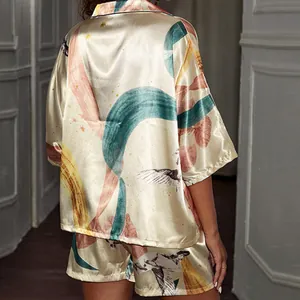 Close-up detail of luxurious satin pajama set featuring an artistic abstract bird print