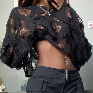 Close-up of black distressed hollow-out knit sweater showing ripped texture and style
