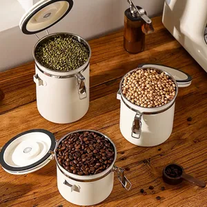 Cream white stainless steel airtight storage jars for coffee beans and grains on wood table