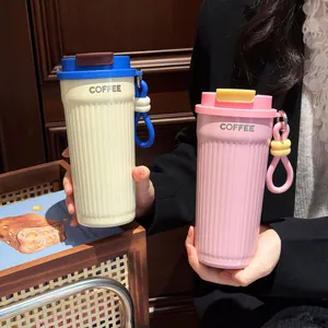 Vista dettagliata di eleganti tazze da caffè in acciaio inox bianche e rosa in mano.
