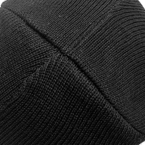 Détail en gros plan montrant le tricot fin et les coutures durables du bonnet noir