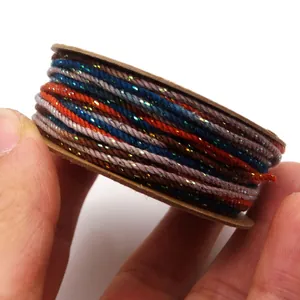 Nahaufnahme von 1,2 mm handgedrehtem Baumwollfaden mit Goldseide auf einer Pappspule