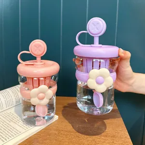 Primo piano di graziose bottiglie d'acqua in plastica con infusore per tè rosa e viola