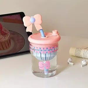 Süßer Glasbecher mit rosa Schleife und Strohhalm, hitzebeständiges Design für den Tisch