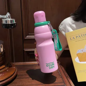 Detail view of pink curvy stainless steel sports bottle with green strap and logo.