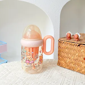 Detailansicht eines niedlichen Milchbechers in Babyflaschenform mit Bärenmuster und Griff