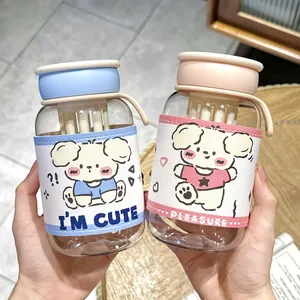 Close-up of cute portable water bottles with cartoon dog leather sleeves in blue and pink.