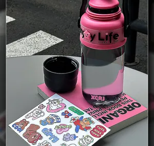 Große rosa Trinkflasche mit Strohhalm und süßen Aufklebern in einer Lifestyle-Umgebung
