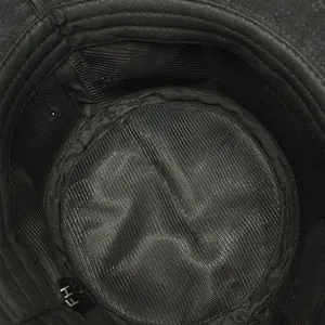 Detail view of breathable mesh lining inside a black cotton sun protection bucket hat