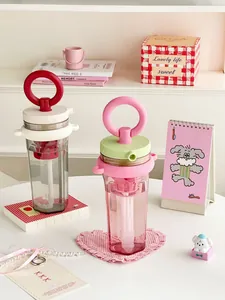 Detailed view of portable water bottles with ring handles and built-in straws
