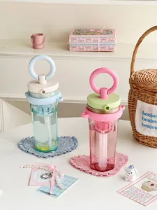 Close-up of pastel aesthetic water bottles with straw and filter for portable tea