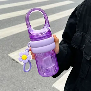 Portable purple water bottle with large handle and flower charm for outdoor use.
