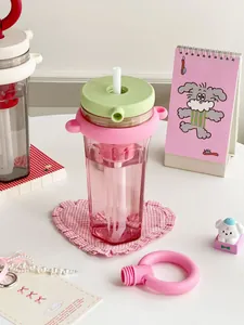Aesthetic portable pink straw cup with tea filter shown in a cute desk setting for girls
