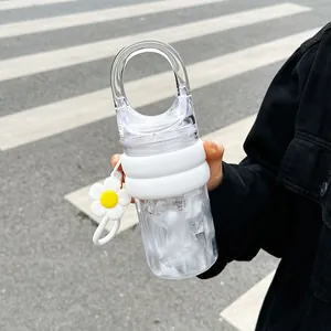 Close-up of a stylish portable clear water bottle with handle and flower charm