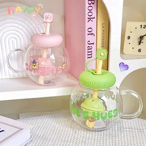 Close-up of two cute round glass cups with pink and green lids and built-in tea filters
