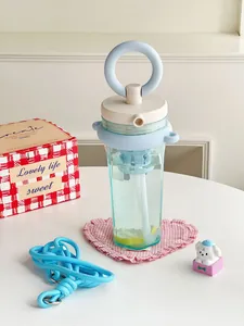 Close-up of stylish portable blue straw cup with tea filter and pink heart coaster