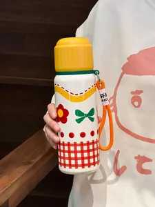 Close-up of a cute cartoon stainless steel water bottle with a vibrant orange carry strap