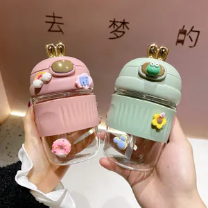 Détails des breloques 3D et du couvercle à oreilles de lapin sur bouteilles en verre rose et vert