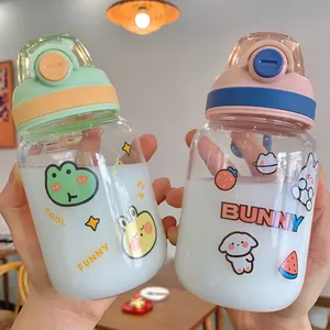Close-up of kawaii glass water bottles with cute cartoon stickers and bounce lids