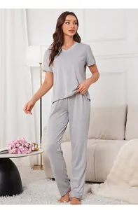 Woman in comfortable grey V-neck loungewear set posing in a bright minimalist living room