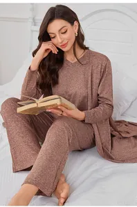 Woman wearing a cozy three-piece brown lounge set with V-neck top and cardigan on a bed