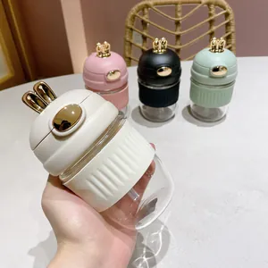 Gros plan d'une bouteille en verre oreilles de lapin avec manchon en silicone et paille