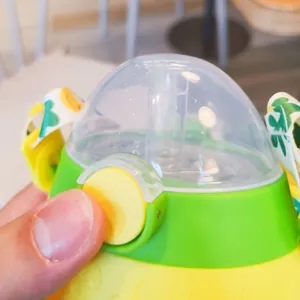 Detalle del botón de apertura rápida en el vaso con pajita para niños con diseño de frutas