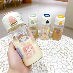 Detailed close-up of a cute cartoon glass water bottle featuring a flip lid and straw