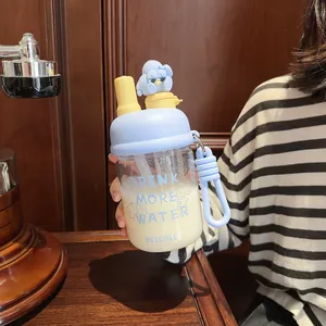 Detail view of a portable cartoon glass water bottle featuring a straw and cute character lid