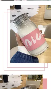 Detail einer tragbaren Glastrinkflasche mit rosa wärmeisolierender Schutzhülle