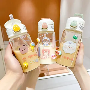 Detailed view of three cute cartoon glass water bottles featuring straws and unique 3D charms
