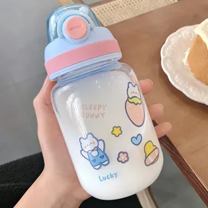 Close-up of a cute pastel water bottle with cartoon bunny and strawberry illustrations