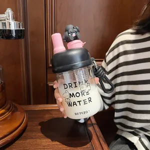 Detail view of a portable glass straw water bottle with a cute black cartoon figurine topper.
